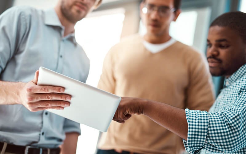 Ensure a successful transition to the cloud Close up of three businessmen holding tablet device