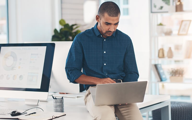 Build a robust cloud strategy Businessman on laptop computer in bright open office