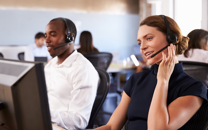 24/7 remote IT support from certified experts IT support experts on headsets wait to take calls in Remote Network Operations Center