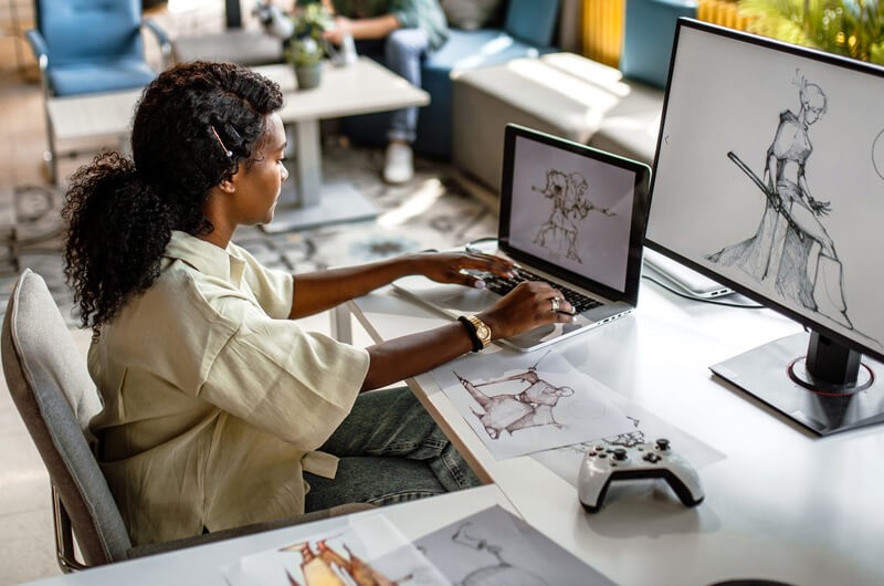 We help build, customize and manage your approved catalog Designer working at her desk in office